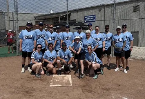 BCM's staff baseball team in matching jerseys at the diamond