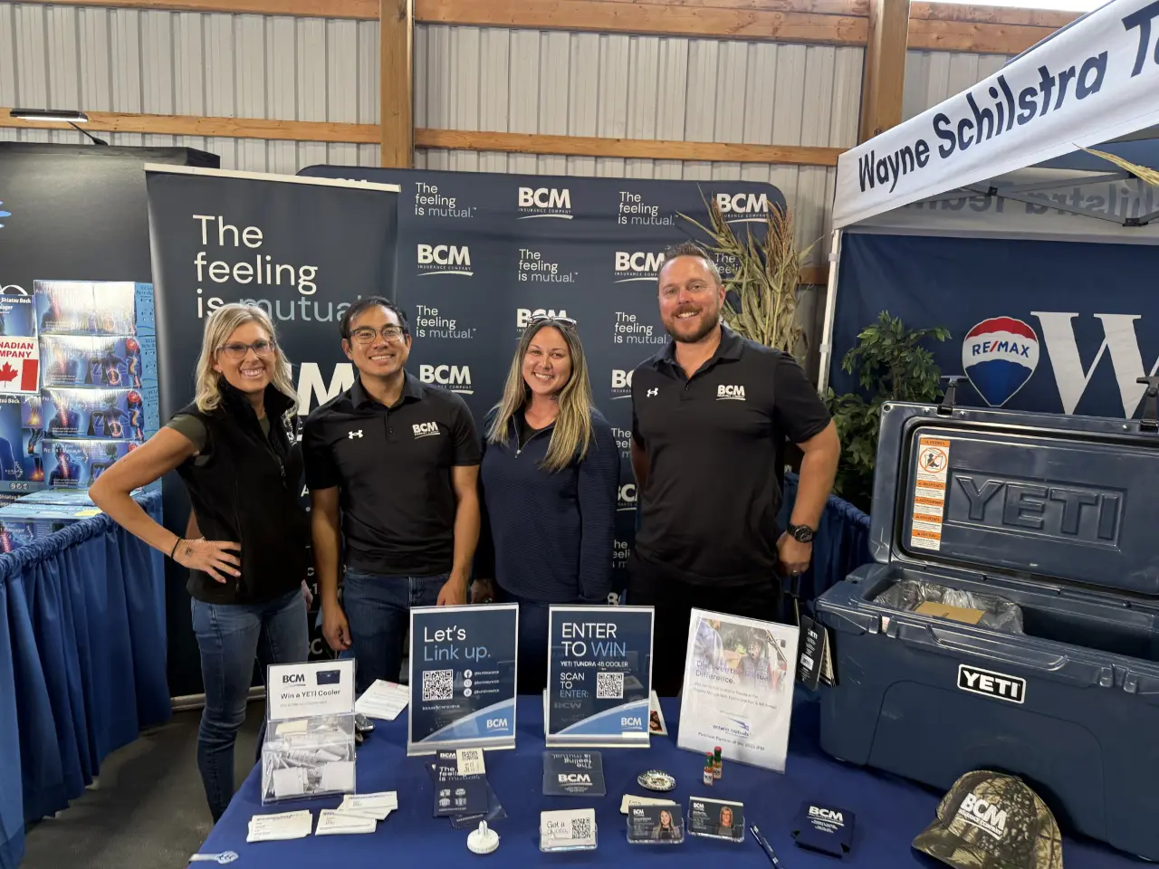 Four BCM Insurance staff at the BCM booth at a community event