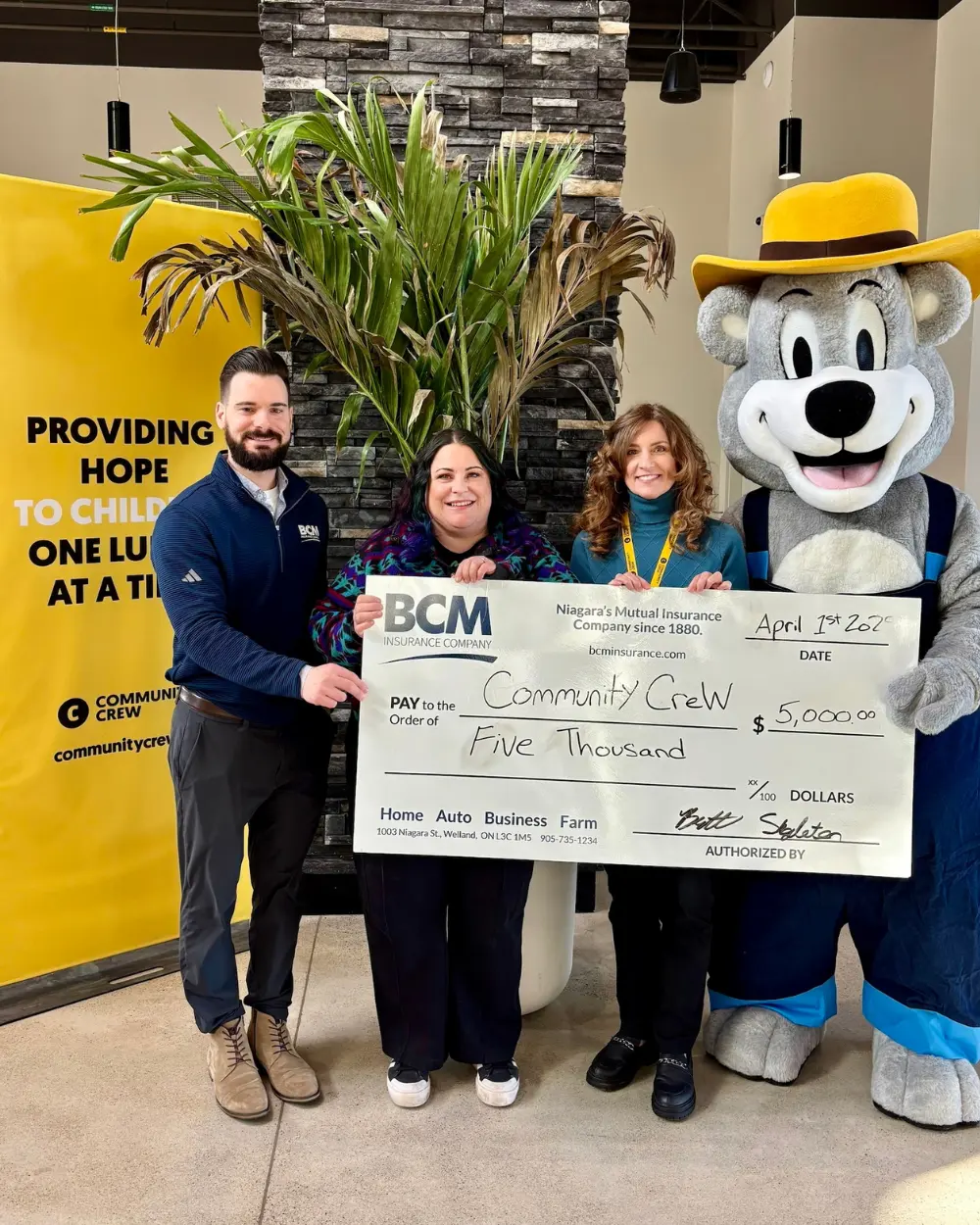 BCM staff and mascot Bertie presenting a $5,000 cheque to Community Crew