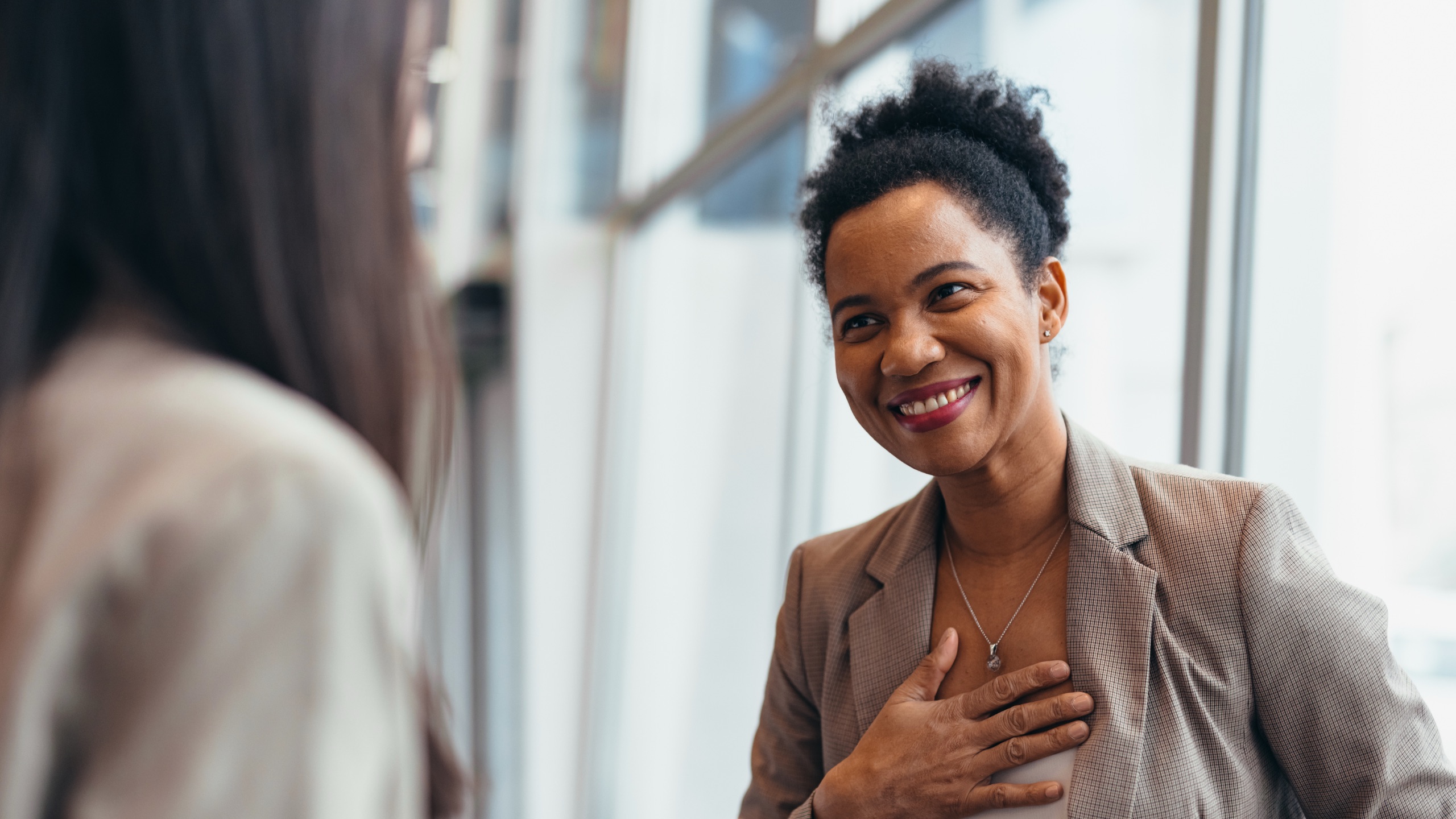 A BCM team member smiling warmly during a conversation with a colleague